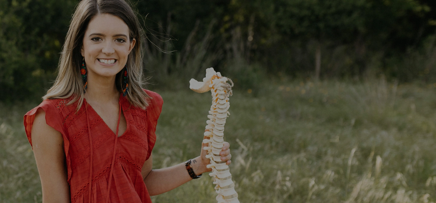 chiropractor in red holding a imitation spine